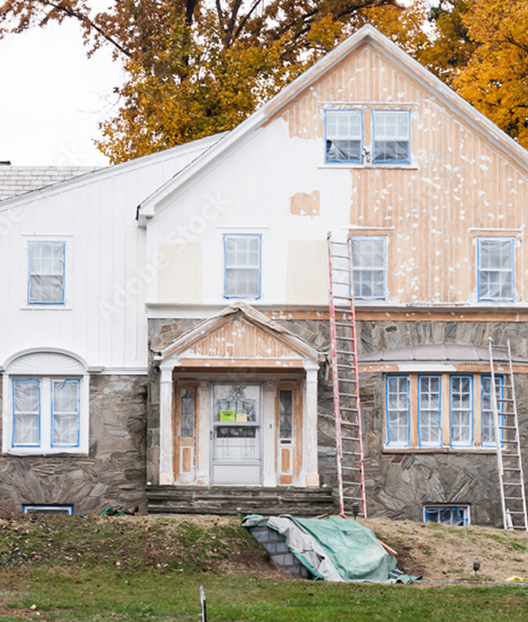 A professional repairing the exterior of a home